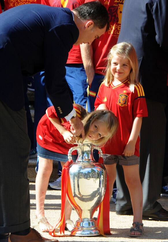 Spain's Crown Prince Felipe points as Spain's Princess Leonor puts her arm into the Euro 2012 trophy next to Princess Sofia right during a visit by the national soccer team members to the Zarzuela Palace in Madrid.