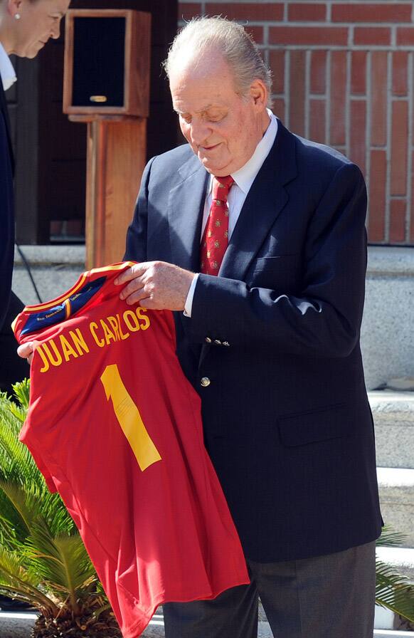 Spain's King Juan Carlos holds a Spanish soccer shirt with his name on it that was presented to him by Spain's national soccer team players at the Zarzuela Palace in Madrid, a day after winning the trophy by beating Italy in the final in Kiev.