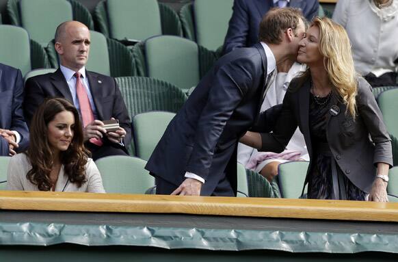 Britain's Prince William greets retired tennis player Steffi Graf, as Kate, Duchess of Cambridge, looks on as Andy Murray of Britain faces David Ferrer of Spain in a quarterfinals match at the All England Lawn Tennis Championships at Wimbledon.