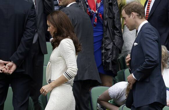 Britain's Prince William and his wife Kate, Duchess of Cambridge leave the Royal box as rain delays play in a quarterfinals match between Roger Federer of Switzerland and Mikhail Youzhny of Russia at the All England Lawn Tennis Championships at Wimbledon.