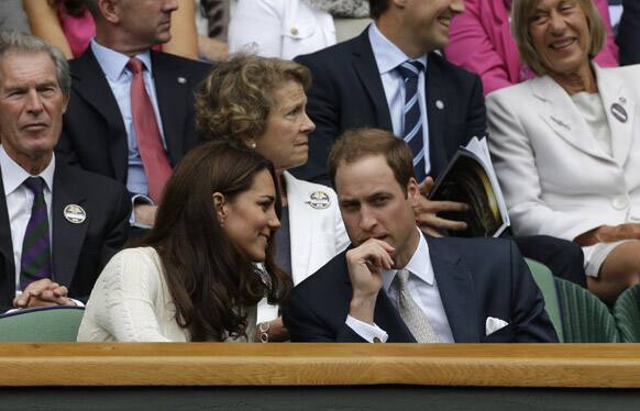 Britain's Prince William and his wife Kate, Duchess of Cambridge speak to each other during the quarterfinals match between Roger Federer of Switzerland and Mikhail Youzhny of Russia at the All England Lawn Tennis Championships at Wimbledon.