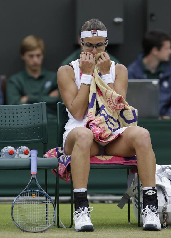 Yaroslava Shvedova of Kazakhstan wipes her face during a fourth round singles match against Serena Williams of the United States at the All England Lawn Tennis Championships at Wimbledon.