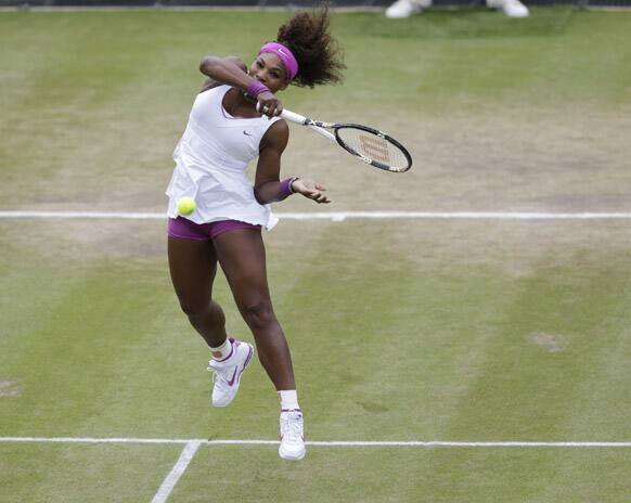 Serena Williams of the United States returns a shot to Yaroslava Shvedova of Kazakhstan during a fourth round women's singles match at the All England Lawn Tennis Championships at Wimbledon.