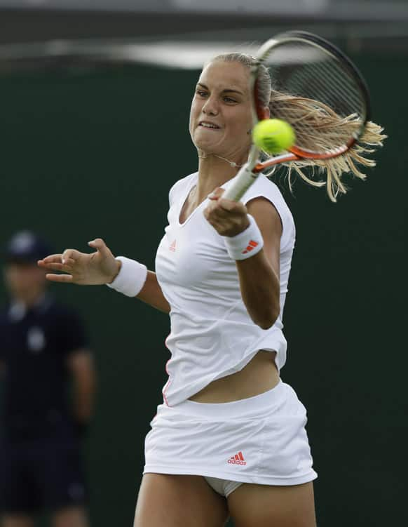 Arantxa Rus of Netherlands returns a shot to Peng Shuai of China during a third round women's singles match at the All England Lawn Tennis Championships at Wimbledon.