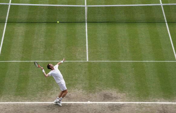 Andy Murray of Britain serves to Roger Federer of Switzerland during the men's singles final match at the All England Lawn Tennis Championships at Wimbledon, England, Sunday, July 8, 2012