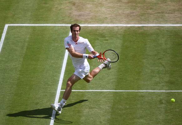 Andy Murray of Britain plays a shot to Roger Federer of Switzerland during the men's singles final match at the All England Lawn Tennis Championships at Wimbledon, England, Sunday, July 8, 2012.