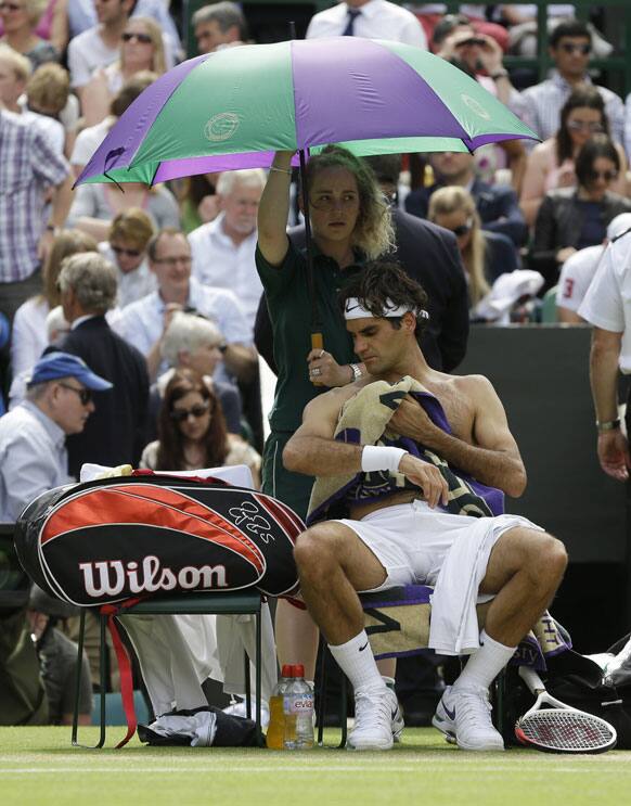 Roger Federer of Switzerland wipes himself with a towel between sets during the men's final match against Andy Murray of Britain at the All England Lawn Tennis Championships at Wimbledon.