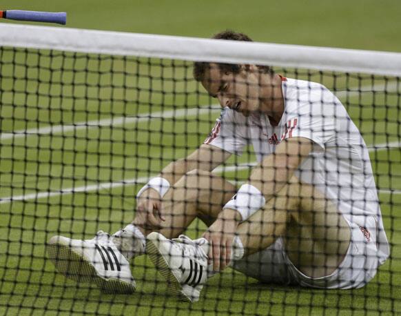 Andy Murray of Britain sits on the court after falling as he tried to play a return during the men's singles final match against Roger Federer of Switzerland at the All England Lawn Tennis Championships at Wimbledon, England, Sunday, July 8, 2012.