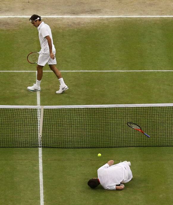 Andy Murray of Britain, front, takes a fall during the men's singles final match against Roger Federer of Switzerland at the All England Lawn Tennis Championships at Wimbledon, England, Sunday, July 8, 2012