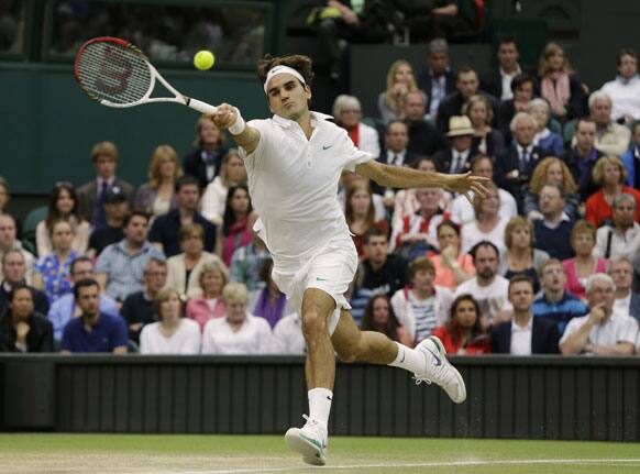 Roger Federer of Switzerland plays a shot to Andy Murray of Britain during the men's final match at the All England Lawn Tennis Championships at Wimbledon, England, Sunday, July 8, 2012.