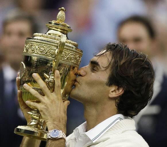 Roger Federer of Switzerland celebrates with the trophy after winning the men's singles final against Andy Murray of Britain at the All England Lawn Tennis Championships at Wimbledon, England, Sunday, July 8, 2012.