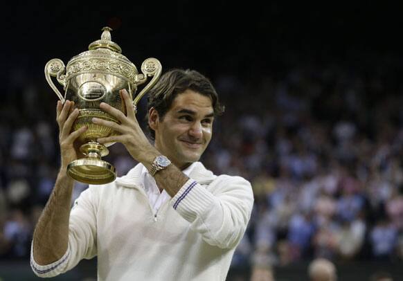 Roger Federer of Switzerland celebrates with the trophy after winning the men's singles final against Andy Murray of Britain at the All England Lawn Tennis Championships at Wimbledon, England, Sunday, July 8, 2012