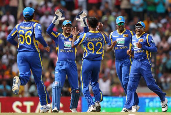 Sri Lanka's bowler Nuwan Kulasekara celebrates the dismissal of Gautam Gambhir, unseen with Kumar Sangakkara, Angelo Mathews, second right and captain Mahela Jayawardene, right during the first one-day international cricket match between Sri Lanka and India.