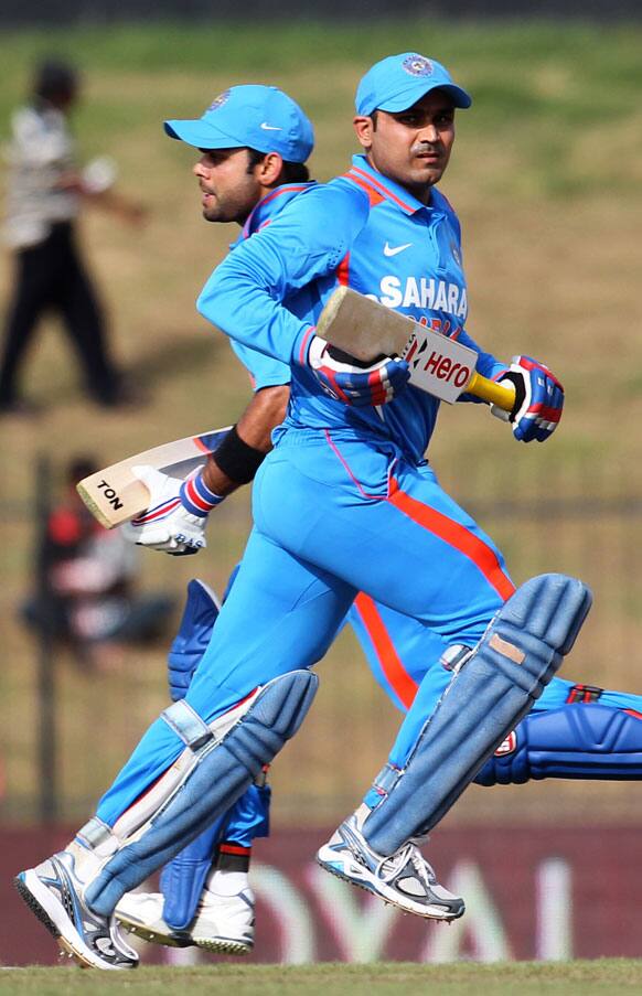 Virat Kohli, left and Virender Sehwag run between the wickets during the first one-day international cricket match between Sri Lanka and India in Hambantota.