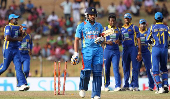 Rohit Sharma, center foreground walks back to the pavilion after his dismissal as Sri Lankans celebrate in the background during the first one-day international cricket match between Sri Lanka and India.