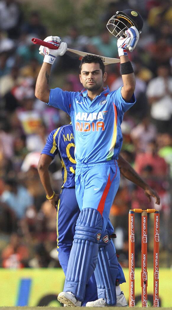 Virat Kohli celebrates after scoring a century during the first one-day international cricket match between Sri Lanka and India in Hambantota.