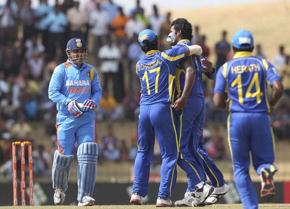 Sri Lanka's bowler Thisara Perera, second right, celebrates the dismissal of India's batsman Virender Sehwag, left, with teammates during the second one-day international cricket match between Sri Lanka and India in Hambantota, Sri Lanka.