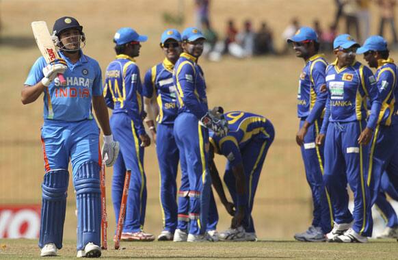 Rohit Sharma walks back to the pavilion after his dismissal as Sri Lanka's crickets celebrate in the back ground during the second one-day international cricket match between Sri Lanka and India in Hambantota.