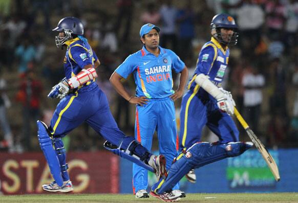 Upul Tharanga, right and Tillakaratne Dilshan, left runs between the wickets as India's Rohit Sharma, center watches during the second one-day international cricket match between Sri Lanka and India in Hambantota.