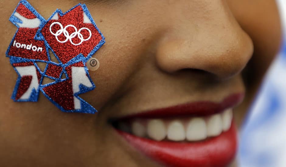 A young woman wears a London Olympics logo on her cheek outside the Olympic Park ahead of the 2012 Summer Olympics Opening Ceremony in London.