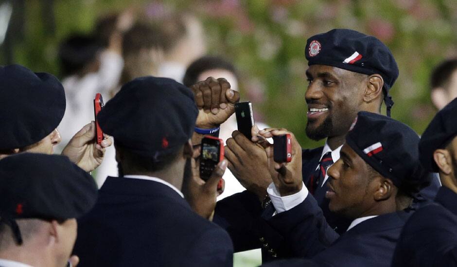 Professional basketball player LeBron James takes pictures with members of the the United States' Olympic team during the Opening Ceremony at the 2012 Summer Olympics in London.