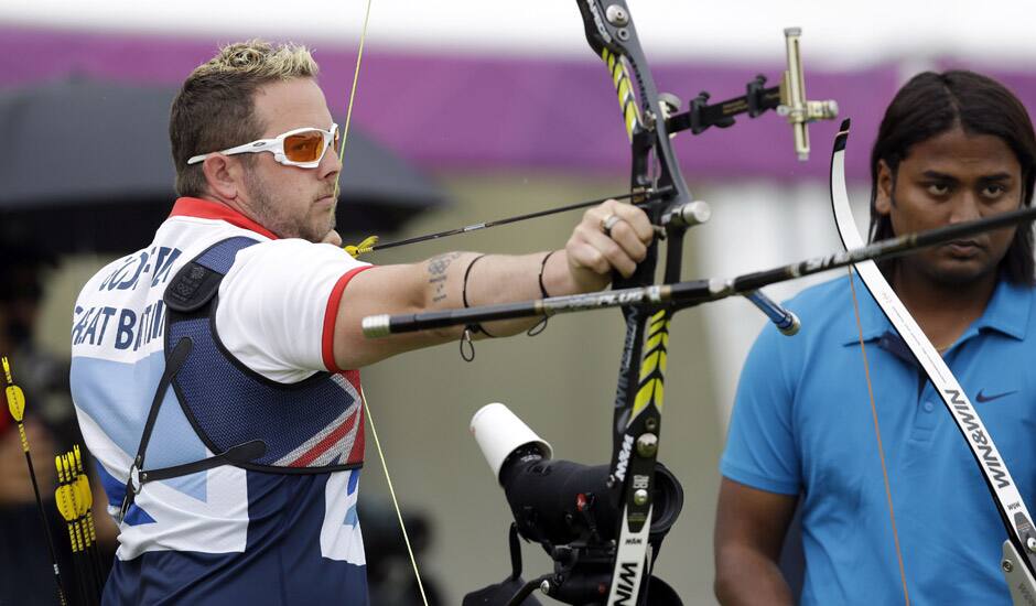 Britain's Laurence Godfrey aims for the target as India's Jayanta Talukdar watches during a individual ranking round at the 2012 Summer Olympics in London.