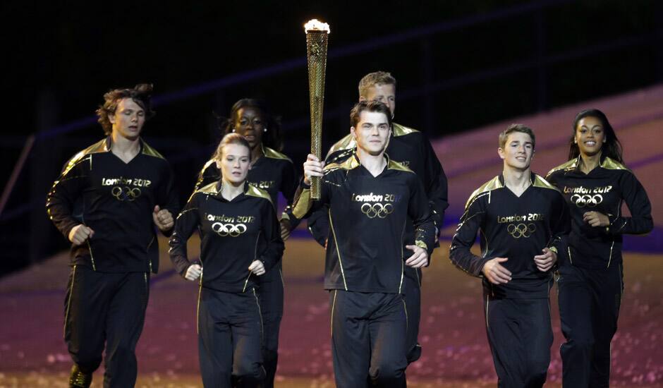 Torchbearers run during the Opening Ceremony at the 2012 Summer Olympics in London. 