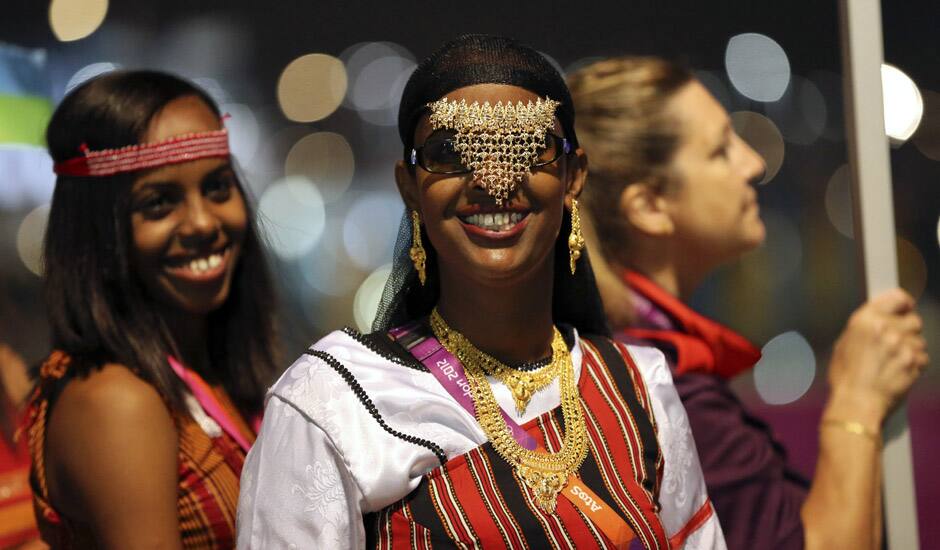 Fardouza Moussa Eguen of Djibouti smiles as she walks with her team to the Olympic Stadium for the Opening Ceremony of the 2012 Summer Olympics in London. 