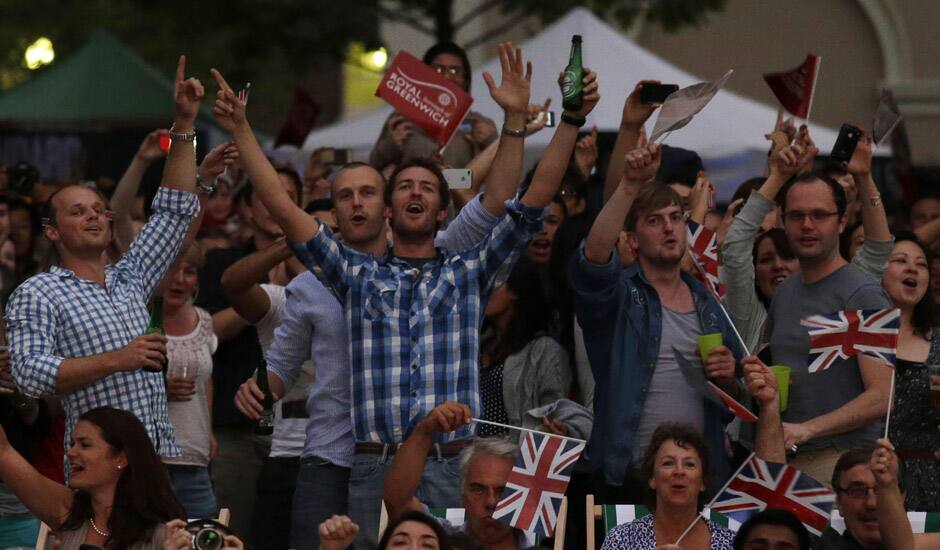 Visitors at a park celebrate during the live telecast of the Opening Ceremony of the 2012 Summer Olympics in London. 