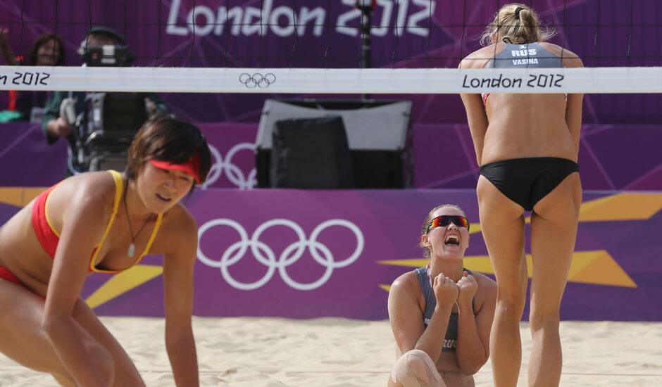 Zhang Xi, from China looks on as Anastasia Vasina, from Russia celebrates with her teammate Anna Vozakova, winning a point during their Beach Volleyball match at the 2012 Summer Olympics.