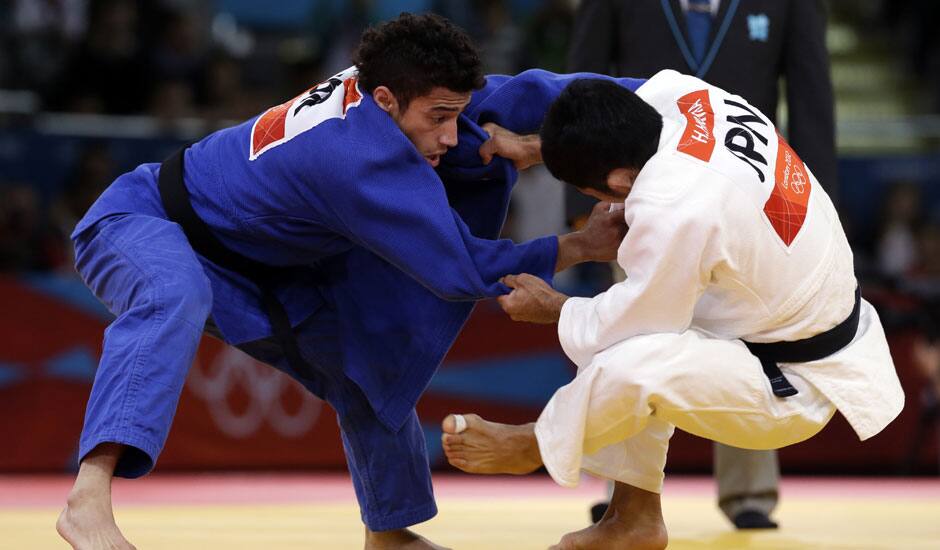 Hiroaki Hiraoka of Japan competes against Ashley McKenzie of Great Britain (in blue) during the elimination round of the men's 60kg judo competition at the 2012 Summer Olympics.