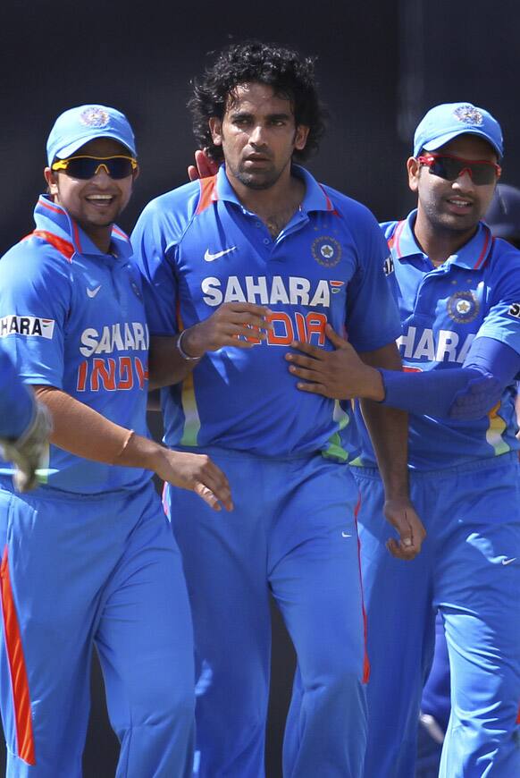 Zaheer Khan celebrates the dismissal of Sri Lanka's batsman Upul Tharanga, with teammates Suresh Raina and Rohit Sharma during their third one-day international cricket match in Colombo.