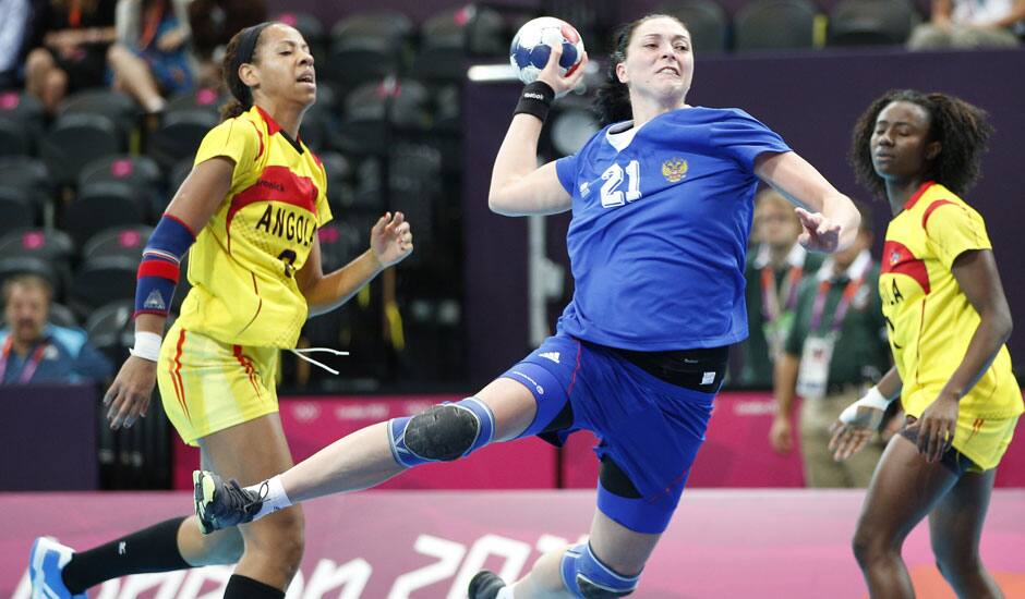 Victoria Zhilinskayte of Russia, center, takes a shot at goal as Angola's Nair Almeida, left, and Natalia Bernardo, right, watch during their women's handball preliminary match at the 2012 Summer Olympics.