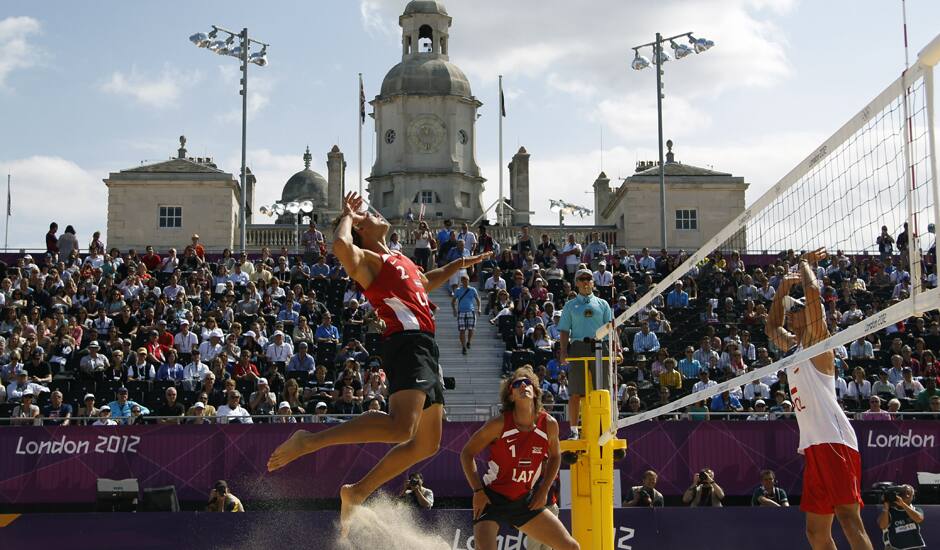 Ruslans Sorokins, left from Latvia leaps to spike a ball during the Beach Volleyball match against Poland at the 2012 Summer Olympics.