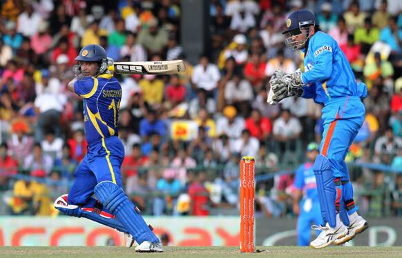 Sri Lanka's batsman Kumar Sangakkara bats as India's wickets keeper captain Mahendra Singh Dhoni watches during the third one-day international cricket match between India and Sri Lanka in Colombo.