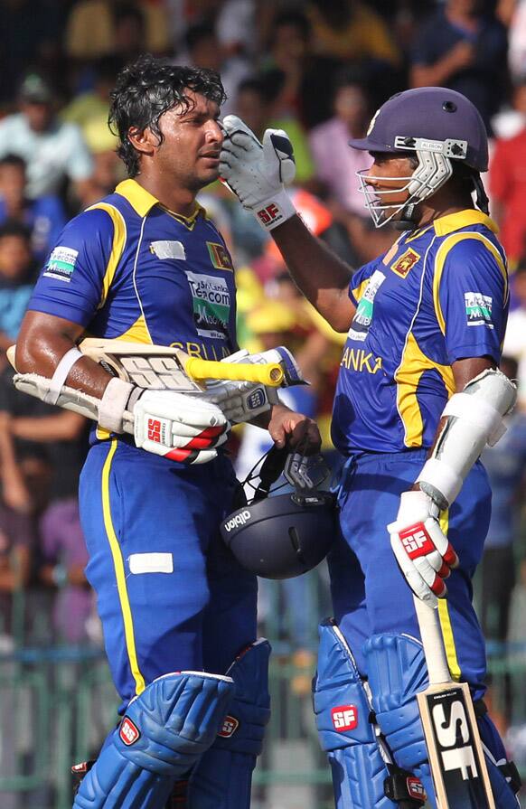 Mahela Jayawardene congratulates batsman Kumar Sangakkara as he reaches a half-century during the third one-day international cricket match between India and Sri Lanka in Colombo.