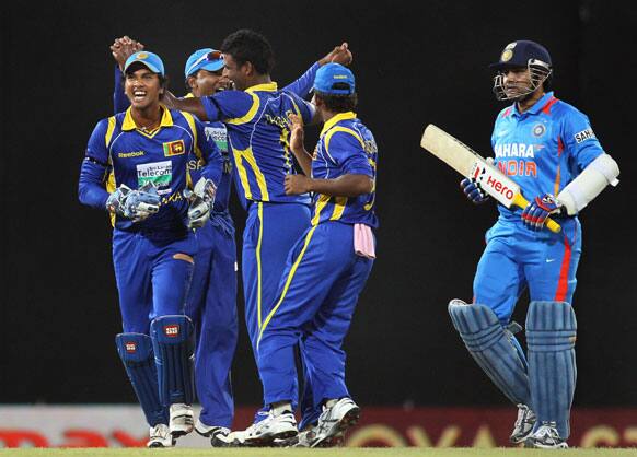 Sri Lanka's bowler Thisara Perera, third left celebrates the dismissal of India's batsman Virender Sehwag, right with wicket keeper Dinesh Chandimal, left and others during the third one-day international cricket match between India and Sri Lanka.