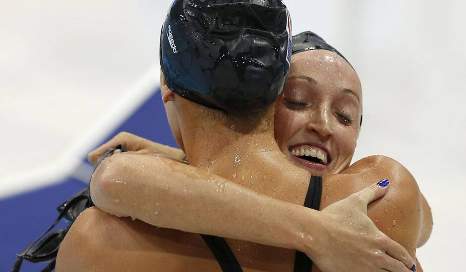 United States' Claire Donahue, right, embraces United States' Dana Vollmer after competing in the women's 100-meter butterfly swimming semifinal at the Aquatics Centre in the Olympic Park during the 2012 Summer Olympics in London.