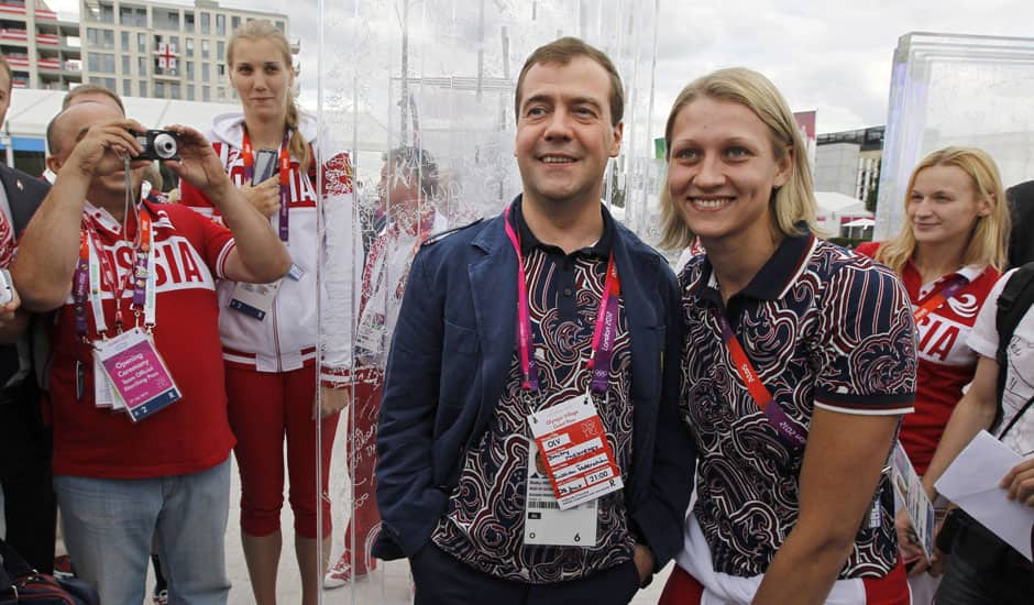 Russian Prime Minister Dmitry Medvedev center, poses with Russian Olympics team members during his visits to Olympic village at the 2012 Summer Olympics, in London.