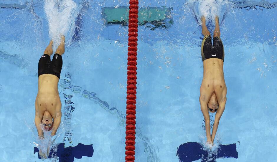 Britain's Liam Tancock, left, and France's Camille Lacourt start in a men's 100-meter backstroke swimming heat at the Aquatics Centre in the Olympic Park during the 2012 Summer Olympics in London.