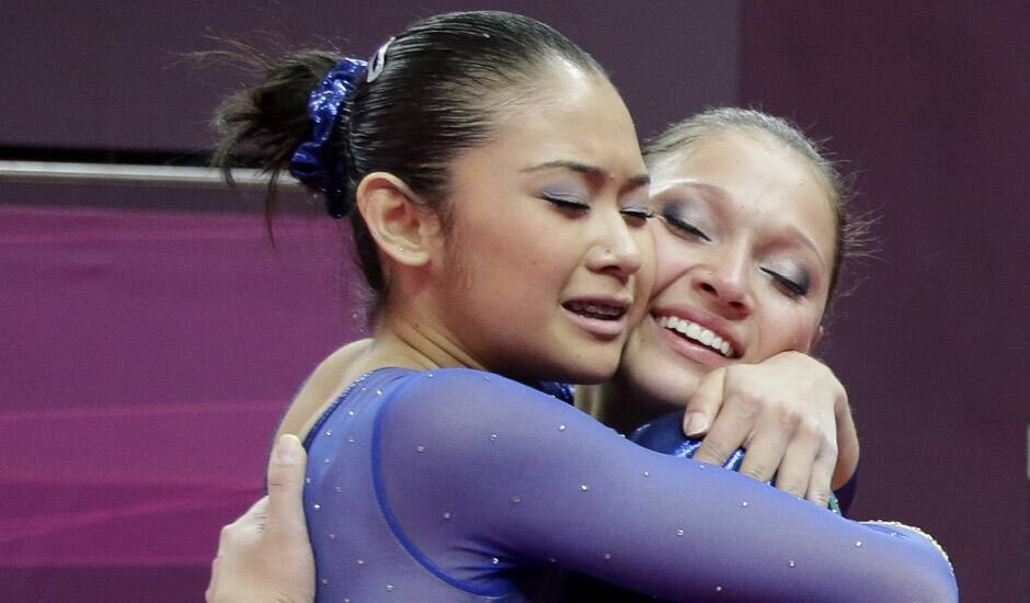 Brazilian gymnast Ethiene Cristina Gonser Franco, right, hugs teammate Harumy Mariko de Freitas, left, during the artistic gymnastics women's qualification at the 2012 Summer Olympics in London.