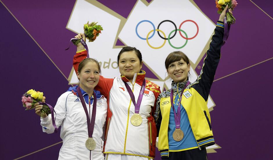 Gold medalist, China's Guo Wenjun celebrates with silver medalist, France's Celine Goberville and bronze medalist Olena Kostevych of Ukraine following the final in the women's 10-meter air pistol event at the 2012 Summer Olympics in London.