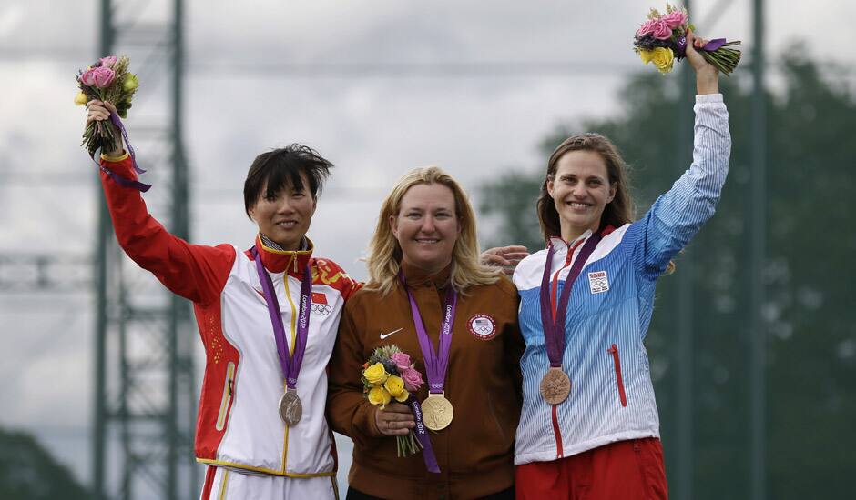 Gold medalist Kimberley Rhode of the United States of America, celebrates with silver medalist, China's Wei Ning, and bronze medalist Danka Bartekova of Slovakia, following the final in the woman's skeet event at the 2012 Summer Olympics in London.