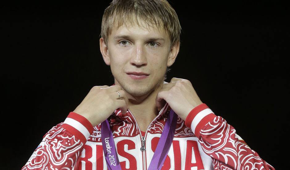 Russia's Nikolay Kovalev stands on the medal stand after winning the bronze medal match against Romania's Rares Dumitrescu in the men's fencing individual sabre at the 2012 Summer Olympics.