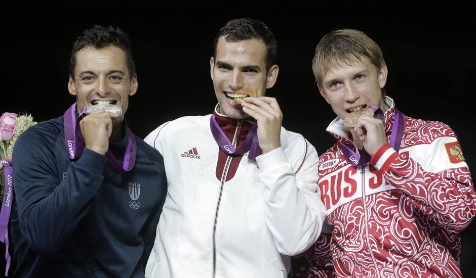 Gold medalist Hungary's Aron Szilagy, center, stands with silver medalist Italy's Diego Occhiuzzi, left, and bronze medalist Russia's Nikolay Kovalev, right, on the medal stand after the men's fencing individual sabre gold medal match at the 2012 Summer Olympics.