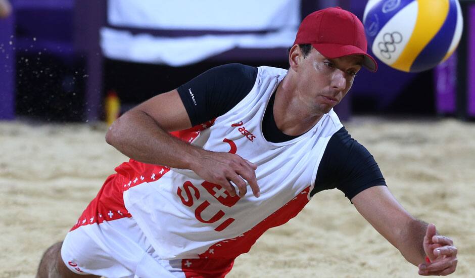 Jefferson Bellaguarda from Switzerland dives for a ball during the Beach Volleyball match against Italy at the 2012 Summer Olympics.