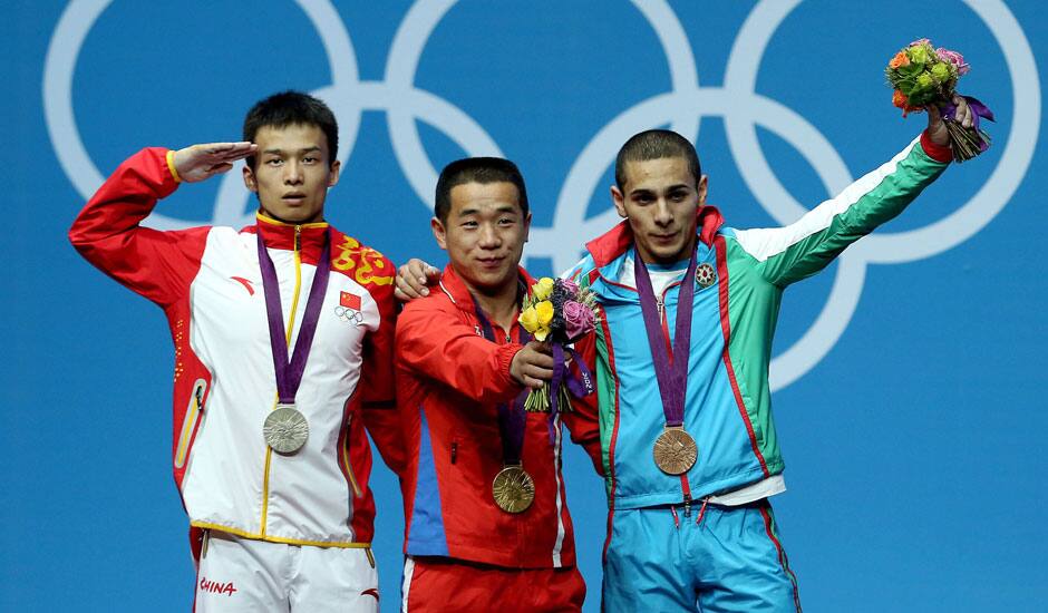 North Korea's Om Yun Chol, center, celebrates winning the gold with China's silver medal winner Wu Jingbiao, left, and Azerbaijan's bronze medal winner Valentin Hristov in the men's 56kg weightlifting competition at the 2012 Summer Olympics.