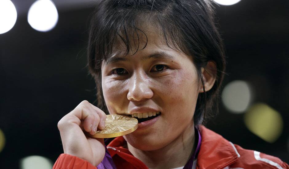 North Korea's An Kum Ae, of North Korea, bites her gold medal from the women's 52-kg judo competition at the 2012 Summer Olympics.