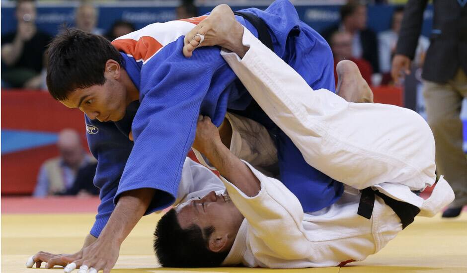 Ki Chun Wang of South Korea competes with Rinat Ibragimov of Kazakhstan, top, during the men's 73-kg judo competition at the 2012 Summer Olympics in London.