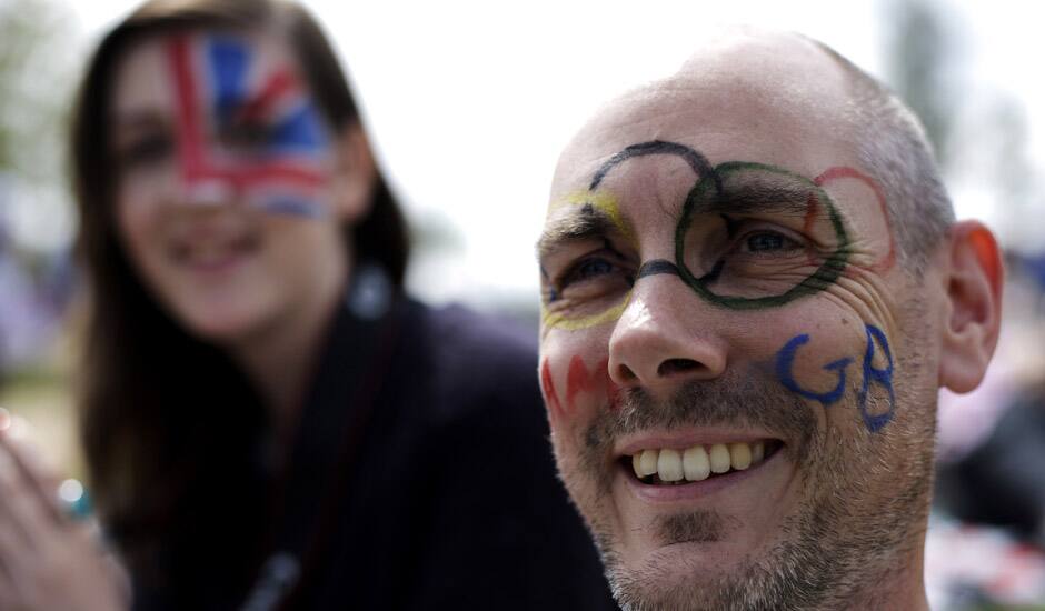 James Dutton of London and his daughter Kattie Dutton, 16, watch a broadcast of an Olympic tennis match on a large screen at Park Live inside Olympic Park during the 2012 Summer Olympics in London.